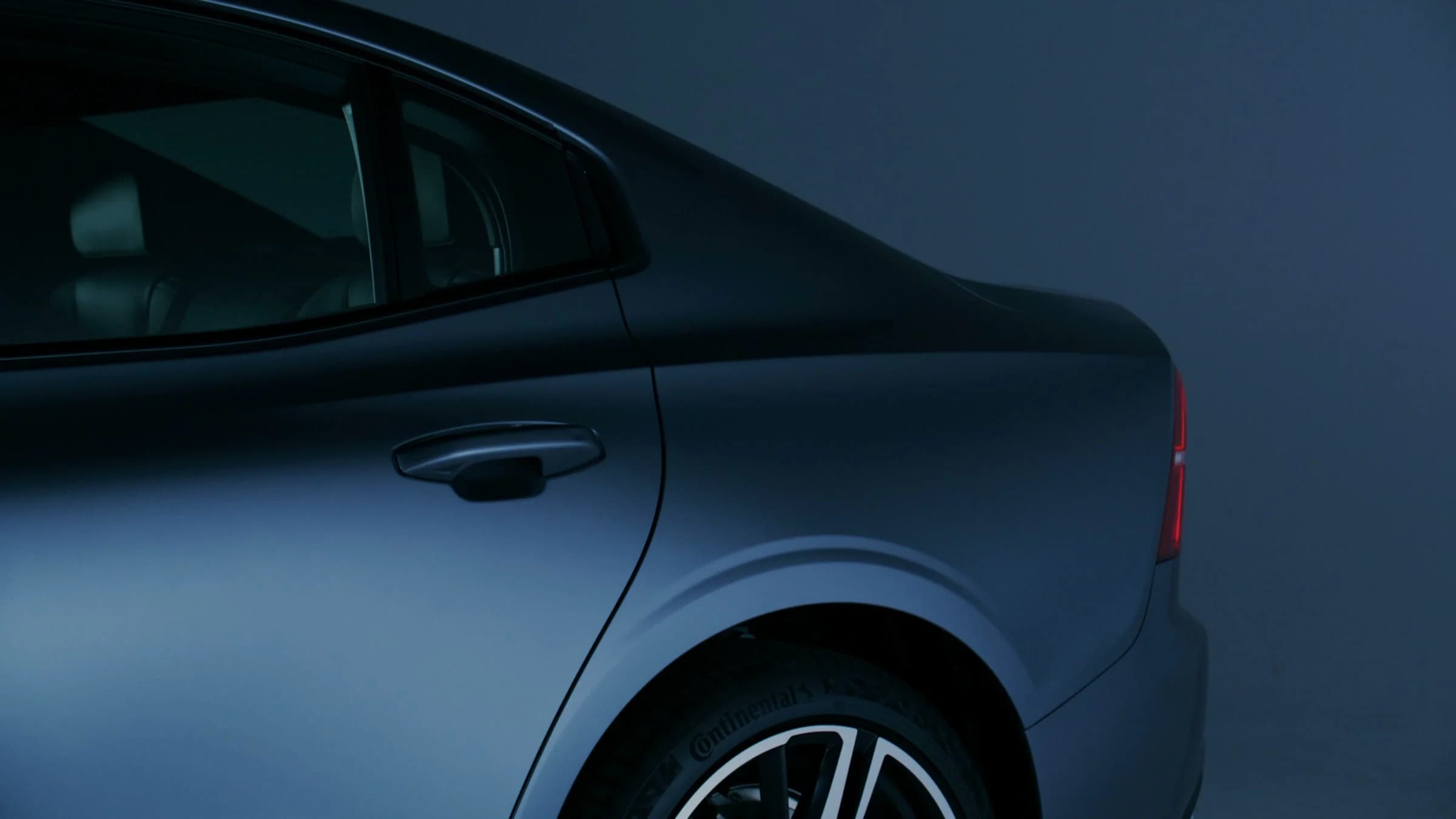 Real graphite vehicle rear quarter photographed in a controlled studio environment.